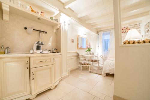 eine Küche mit weißen Schränken und einem Tisch im Zimmer in der Unterkunft Villa Segalla in Rovinj