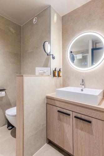 a bathroom with a sink and a mirror at Aldiana Club Ampflwang in Ampflwang im Hausruckwald