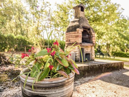 a plant in a pot next to a bird house at Quiet holiday home with shared pool in Salignac