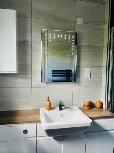 a bathroom with a white sink and a mirror at The Garden House, Broughty Ferry in Broughty Ferry
