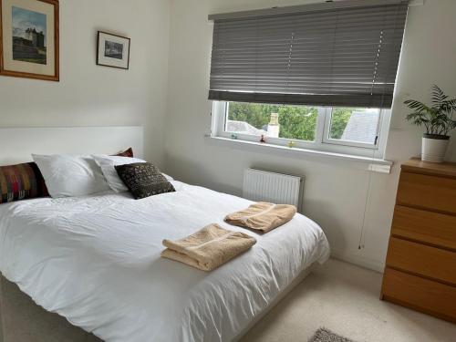 a bedroom with a white bed with towels on it at The Garden House, Broughty Ferry in Broughty Ferry