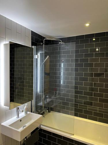 a bathroom with a sink and a shower and a tub at Royal docks in London