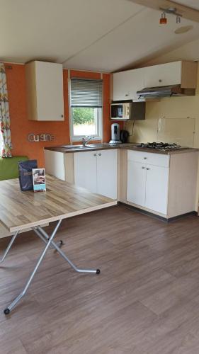 an empty kitchen with a table in a room at Cozy cottage at park de Kniphorst in Anloo