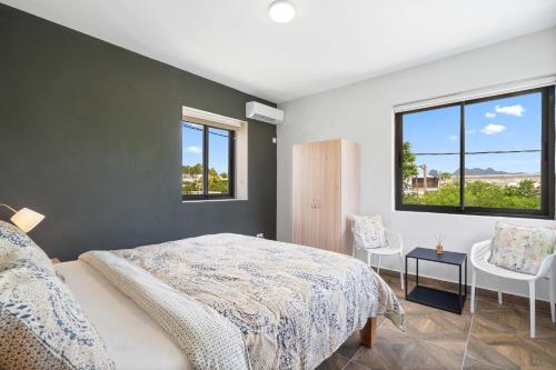 a bedroom with a large bed and two windows at Villa Familiale Luxe Piscine Privée Toit-Terrasse in Balaclava