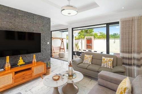a living room with a couch and a flat screen tv at Villa Familiale Luxe Piscine Privée Toit-Terrasse in Balaclava