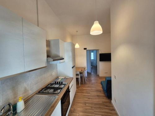 a kitchen with white cabinets and a stove top oven at La casa nel corso in Pomarico