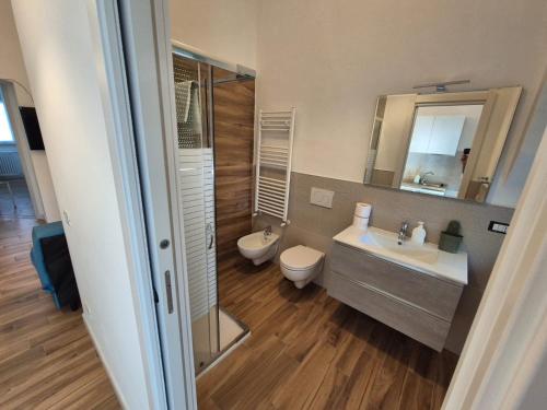 a bathroom with a sink and a toilet and a mirror at La casa nel corso in Pomarico