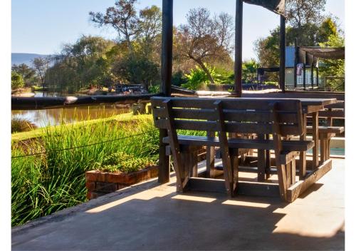 a wooden bench sitting in front of a table at Imbabali Retreat & Venue in Magaliesburg