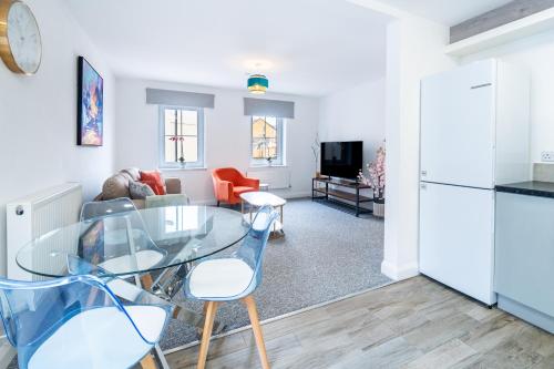 a kitchen and living room with a glass table and chairs at Two-bed Ground Floor Flat in Caerphilly Town Centre in Caerphilly