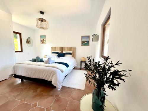 a bedroom with a bed and a vase with a plant at Gîte Diamant, Vallée du Scorff, Nature, Bien-être, 6 personnes in Arzano