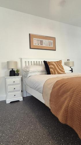 a bedroom with a bed and a nightstand with two lamps at Simply Stay in Monaghan