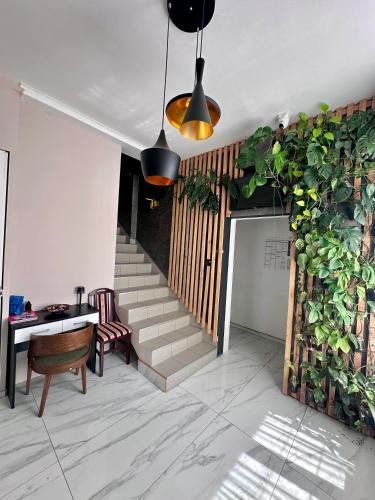 a room with a staircase and a table and a plant at Smeštaj Vortex Sokobanja in Soko Banja