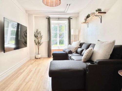 a living room with a black couch and a tv at Le petit d'Antan Parking 10 min from the center in Quebec City