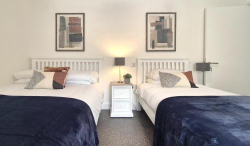 a bedroom with two beds and a table with a lamp at Simply Stay in Monaghan