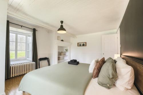a bedroom with a large white bed and a window at Le petit d'Antan Parking 10 min from the center in Quebec City