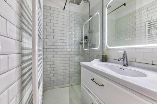 a white bathroom with a sink and a mirror at Modern and Calm 2 Bedroom Appartment T3 in Paris