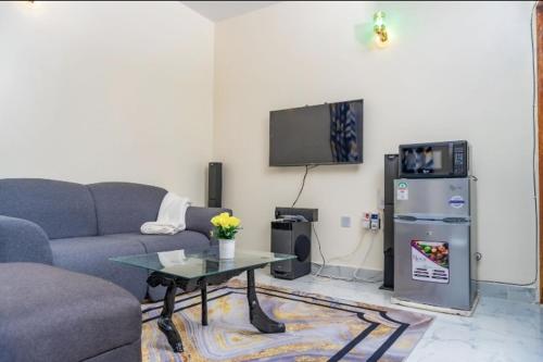 a living room with a couch and a table and a tv at Carsons Nest BnB in Narok