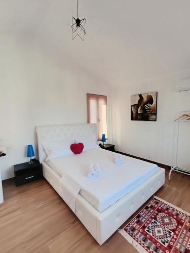 a bedroom with a white bed with a red heart on it at The VIEW Rooms and Terrace in Gjirokastër