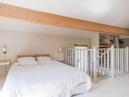 a bedroom with a white bed and a staircase at Holiday Home in Puygareau near Poitiers in Savigny-sous-Faye