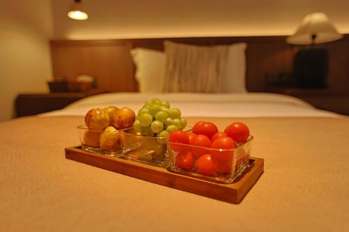 a tray of fruit on a bed in a hotel room at 凤凰古城树喜民宿店Shuxi Guesthouse- Fenghuang Ancient Town in Fenghuang