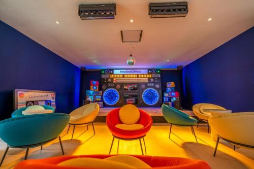 a room with chairs and a dj console at Kandima Maldives in Kudahuvadhoo
