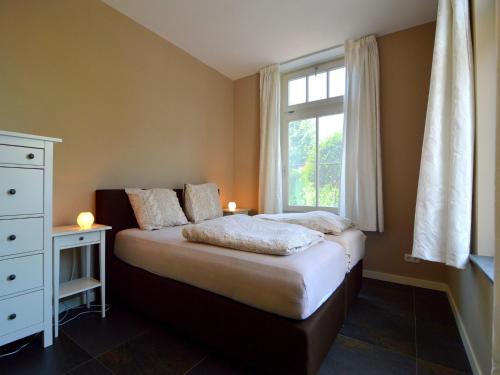 a small bedroom with a bed and a window at Apartment in Posterholt near Meinweg Park in Posterholt