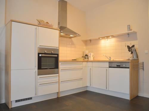 a kitchen with white cabinets and a stove top oven at Apartment in Posterholt near Meinweg Park in Posterholt