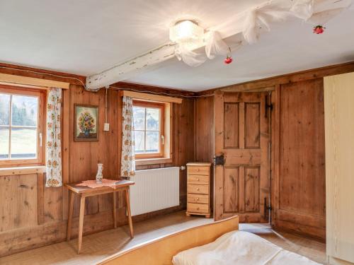 a bedroom with wooden walls and a bed and a table at Chalet in Matrei near Ski Lift & Bus in Matrei in Osttirol