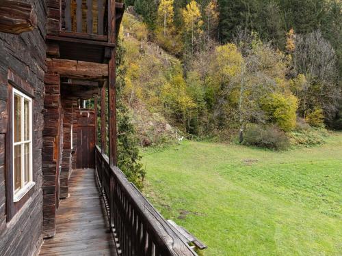 a porch of a log cabin with a view of a field at Chalet in Matrei near Ski Lift & Bus in Matrei in Osttirol
