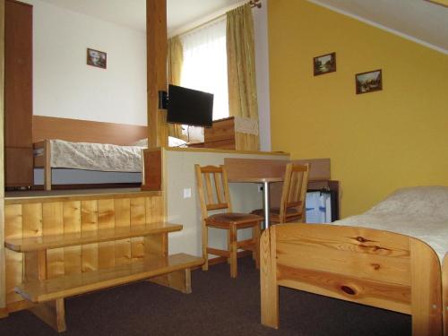 a bedroom with a bed and a table and chairs at Willa Hamernik AGROTURYSTYKA in Tylicz