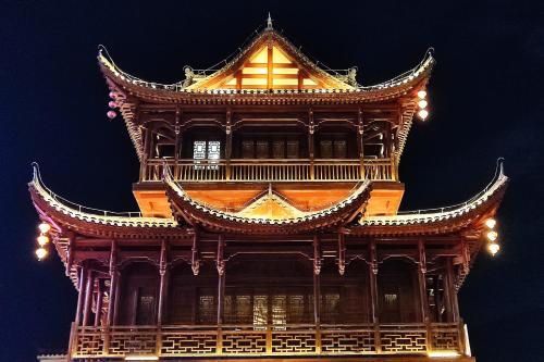 a tall building with a tower at night at 梦境酒店壹号客栈 in Zhangjiajie