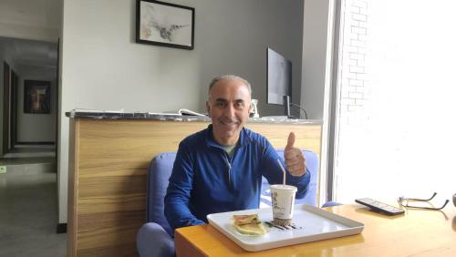 a man giving a thumbs up with a plate of food at 梦境酒店壹号客栈 in Zhangjiajie
