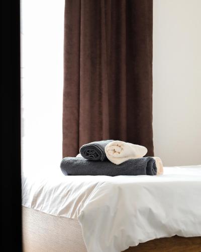 a pile of towels sitting on top of a bed at Nuvelle Boutique Hotel in Prizren
