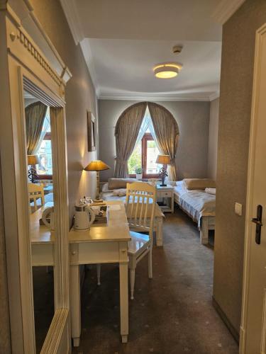 a hotel room with two beds and a desk and a bedroom at Hotel Adler in Byczyna