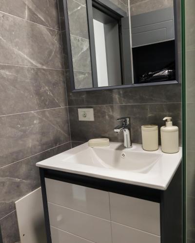 a bathroom with a white sink and a mirror at Nuvelle Boutique Hotel in Prizren