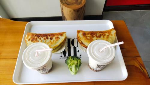 a white plate with two sandwiches and a broccoli at 梦境酒店壹号客栈 in Zhangjiajie
