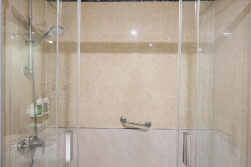 a shower stall with a glass door with a shower at Colectia Hotel Santa Lucía in Seville