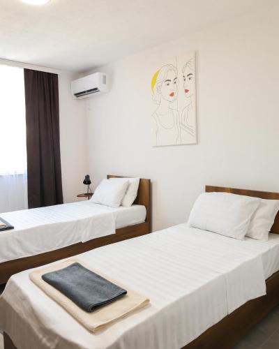 two beds in a hotel room with a towel on them at Nuvelle Boutique Hotel in Prizren
