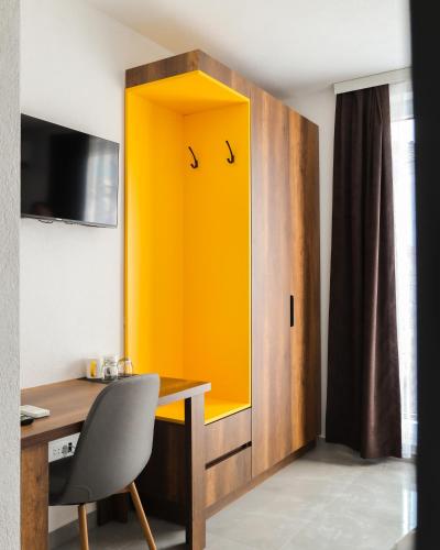 a yellow cabinet in a room with a desk at Nuvelle Boutique Hotel in Prizren