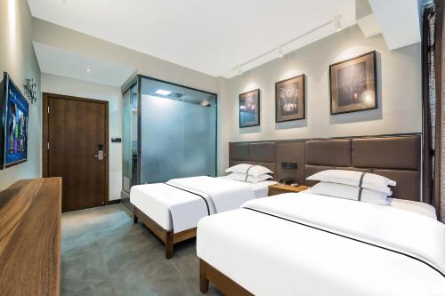 two beds in a hotel room with two beds at 梦境酒店壹号客栈 in Zhangjiajie
