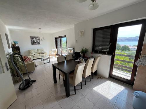 a living room with a dining room table and chairs at Vila Gioya in Karlobag