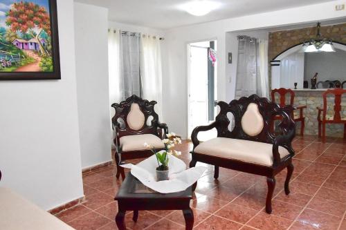 a living room with two chairs and a table at Yolanda's house in Bayaguana
