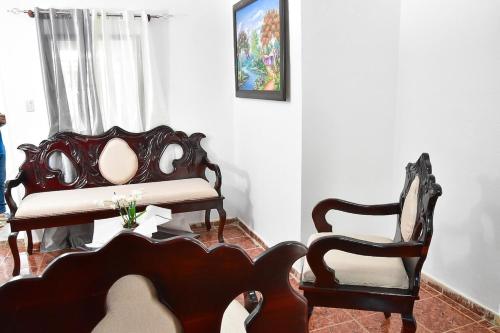 a living room with two chairs and a bench at Yolanda's house in Bayaguana