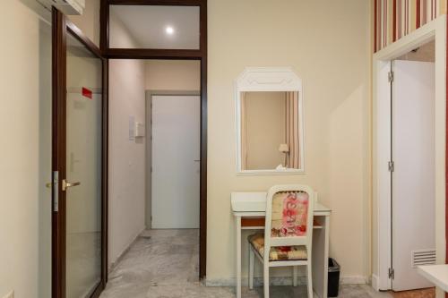 a room with a desk and a mirror and a chair at Colectia Hotel Santa Lucía in Seville