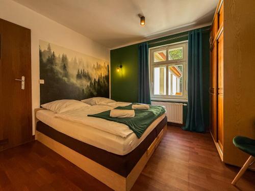 a bedroom with a bed with a painting on the wall at Dworek Szumilas in Prudnik