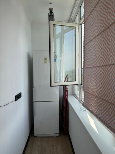 a room with a refrigerator and a window at Уютный уголок Фрунзе in Bishkek