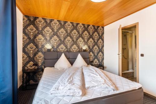 a bed in a bedroom with a wall at Haus Fürstenberg Komplett in Fürstenberg