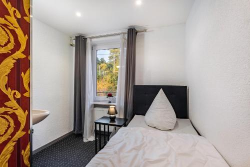 a bedroom with a bed with a pillow and a window at Haus Fürstenberg Komplett in Fürstenberg