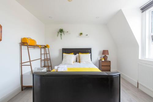 a bedroom with a black bed with yellow sheets at Apartment - Stay 6 - Parking - PetsOK - Stratford in London