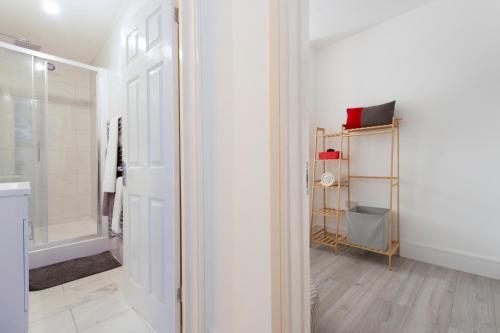 a bathroom with a walk in shower and a white door at Apartment - Stay 6 - Parking - PetsOK - Stratford in London